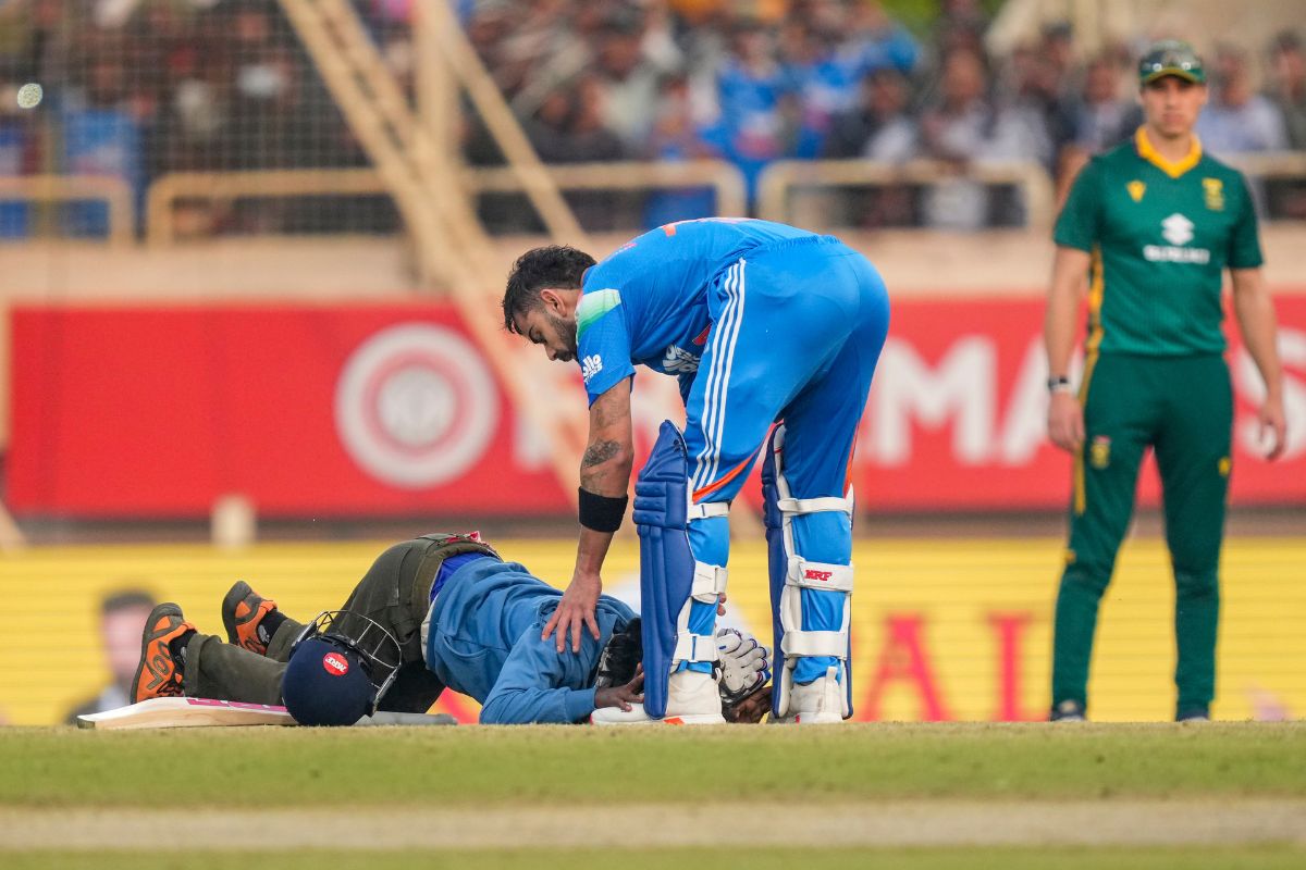 Viral moment of a fan touching Virat Kohli's feet during the Ranchi ODI match while security rushes in.